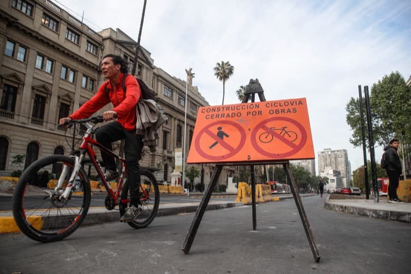 Ciclista frente a un letrero de ciclovía cerrada por obras en Santiago
